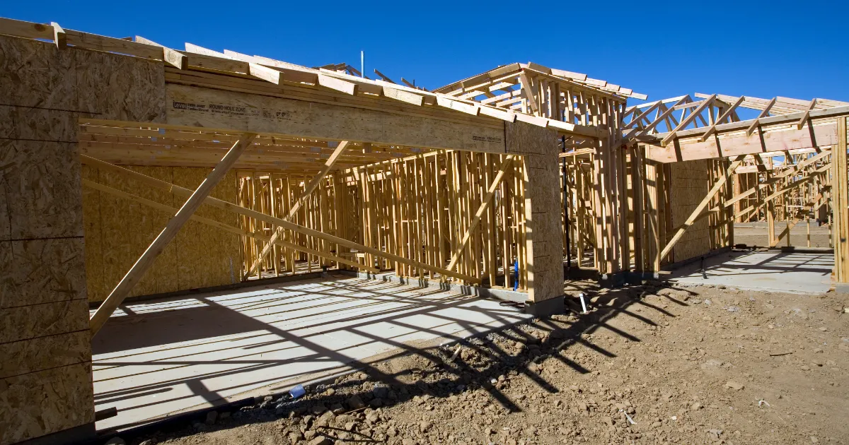 Site preparation costs before building a house - excavator grading a residential lot